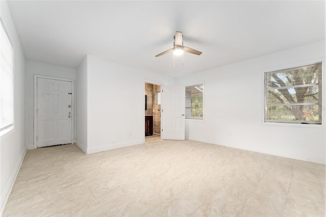spare room featuring a wealth of natural light, baseboards, and ceiling fan