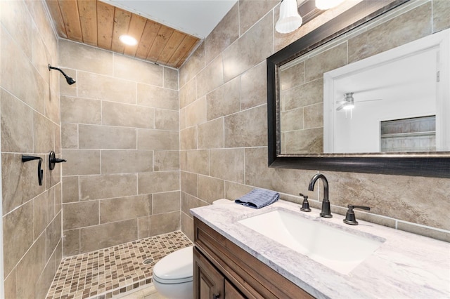 full bath with a shower stall, ceiling fan, vanity, and toilet