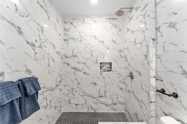 bathroom featuring a marble finish shower