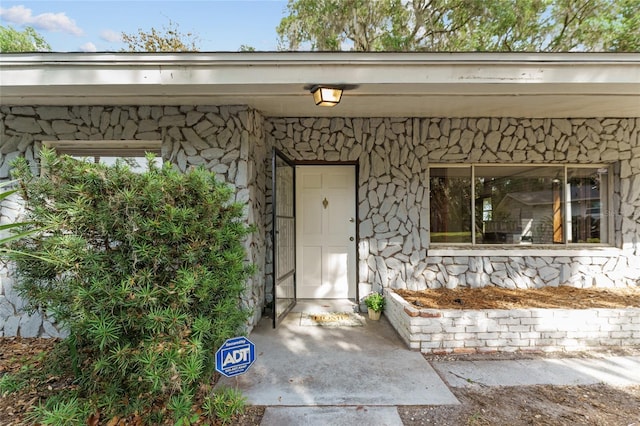 doorway to property with stone siding