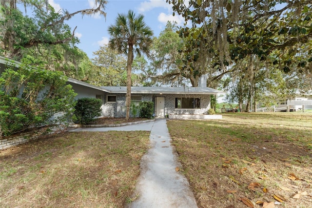 view of front facade featuring a front lawn and a chimney