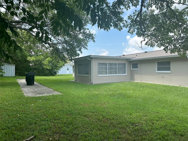 79 S Harrison St, Beverly Hills, FL 34465 - back of property with a lawn, stucco siding, an outdoor structure, a patio, and a shed