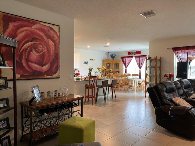 living room with tile patterned floors and a textured ceiling
