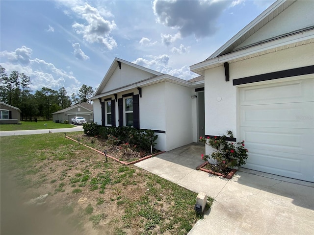 entrance to property with stucco siding and an attached garage