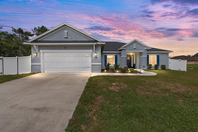 ranch-style home featuring concrete driveway, stucco siding, an attached garage, and a gate