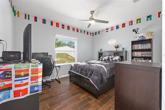 bedroom with dark wood-type flooring, a desk, baseboards, and a ceiling fan