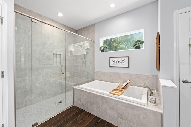 bathroom featuring a garden tub, a shower stall, wood finished floors, and recessed lighting