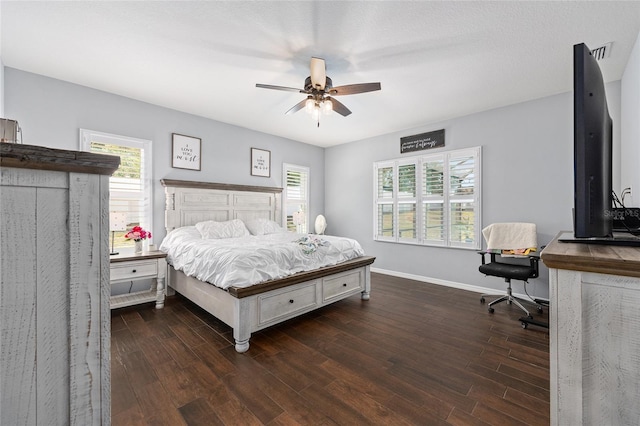 bedroom featuring wood finished floors, multiple windows, and baseboards