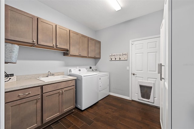clothes washing area featuring cabinet space, dark wood-style floors, washer and clothes dryer, and baseboards