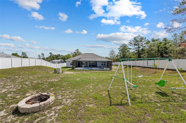 view of yard featuring a playground, an outdoor fire pit, and a swimming pool