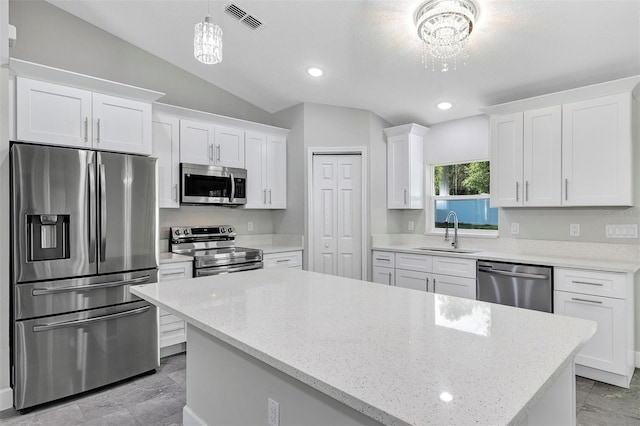 kitchen with a sink, visible vents, a center island, white cabinets, and appliances with stainless steel finishes