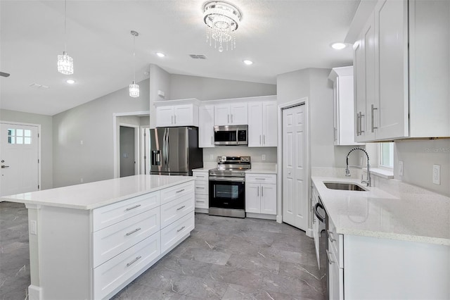 kitchen with a sink, visible vents, vaulted ceiling, white cabinetry, and appliances with stainless steel finishes