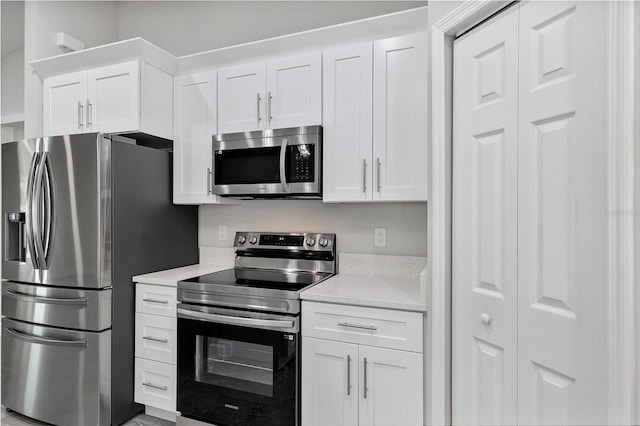 kitchen with light countertops, stainless steel appliances, and white cabinets