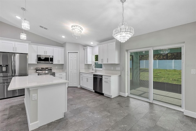 kitchen featuring light countertops, stainless steel appliances, baseboards, and lofted ceiling