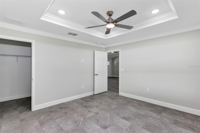 unfurnished bedroom featuring visible vents, baseboards, a raised ceiling, and ornamental molding
