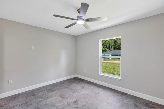 empty room featuring baseboards and a ceiling fan