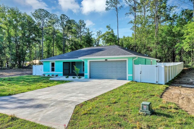 single story home with driveway, fence, a garage, stucco siding, and a front lawn