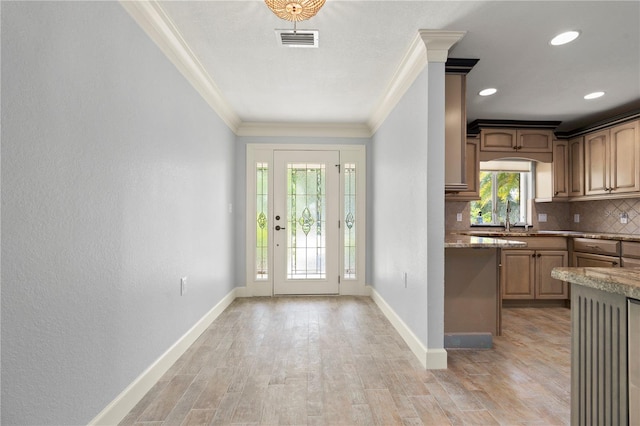 414 NW 8th Ave, Crystal River, FL 34428 - kitchen featuring crown molding, backsplash, light wood-style floors, and baseboards