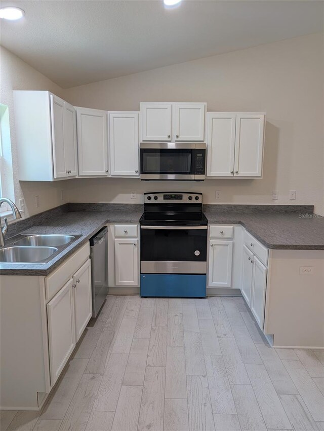 267 Oak Lane Trak, Ocala, FL 34472 - kitchen featuring a sink, lofted ceiling, stainless steel appliances, light wood finished floors, and white cabinets