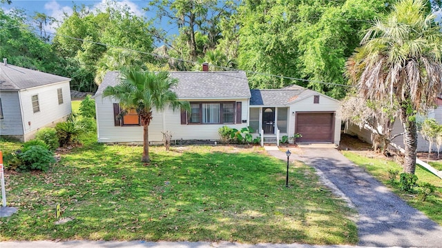 single story home featuring a garage, asphalt driveway, a front lawn, and roof with shingles