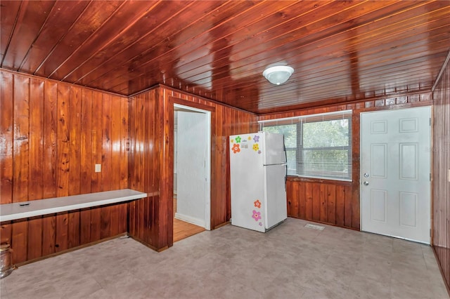 interior space featuring wood walls, tile patterned floors, and wood ceiling