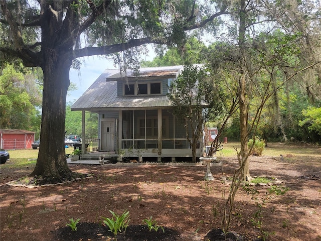 view of front of home with metal roof and a sunroom