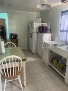 kitchen with light tile patterned flooring and crown molding