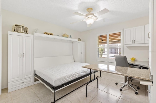 1736 Watts Mill Way, The Villages, FL 32162 - bedroom featuring an office area, light tile patterned flooring, a textured ceiling, and a ceiling fan