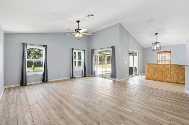 unfurnished living room featuring vaulted ceiling, a chandelier, ceiling fan, light wood-style floors, and baseboards