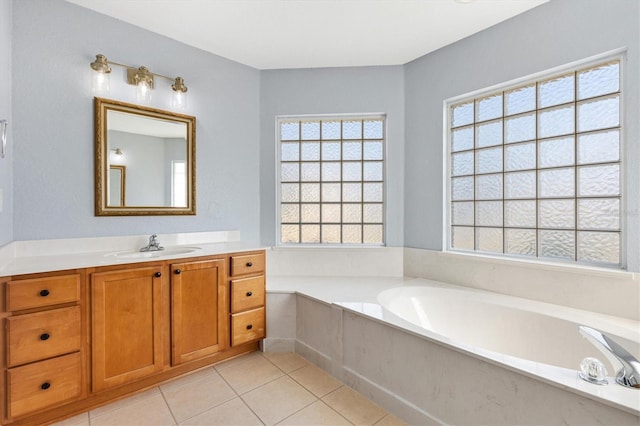 bathroom with plenty of natural light, a garden tub, and vanity