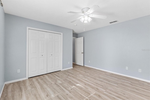 unfurnished bedroom with wood finished floors, baseboards, a closet, and ceiling fan
