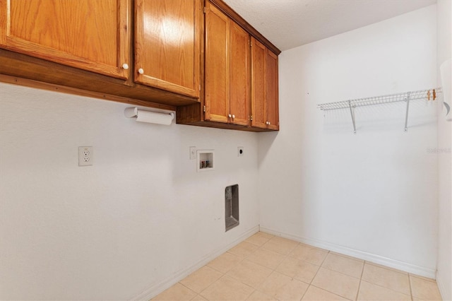 laundry area featuring cabinet space, electric dryer hookup, baseboards, washer hookup, and light tile patterned flooring