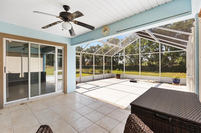 unfurnished sunroom with a ceiling fan and vaulted ceiling