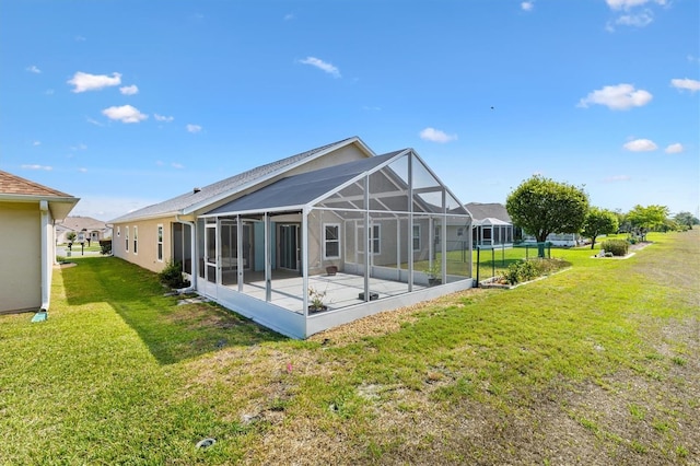 rear view of house featuring a lawn, a patio area, and a lanai