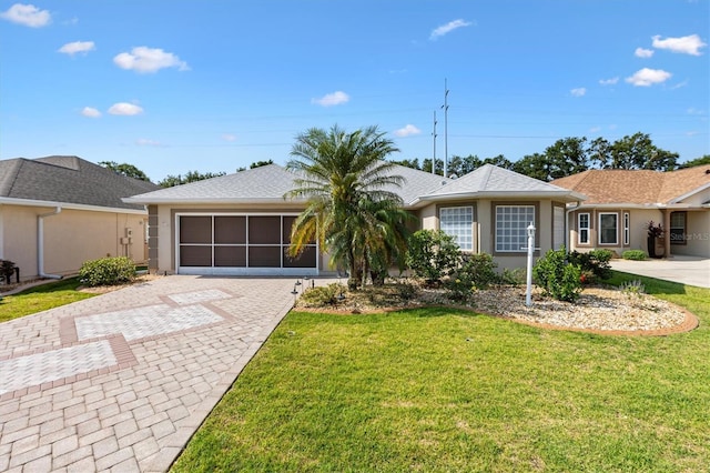ranch-style house with decorative driveway, a front yard, stucco siding, and a garage