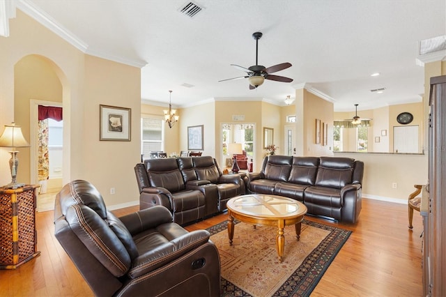 living area with ceiling fan, arched walkways, light wood-style flooring, baseboards, and crown molding