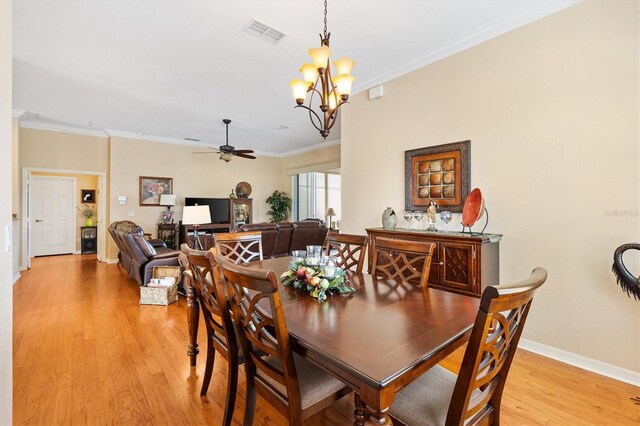 dining space with a ceiling fan, a chandelier, light wood-style floors, crown molding, and baseboards