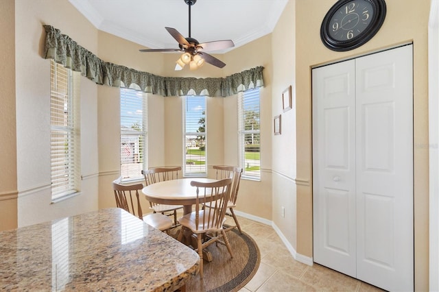 dining space with crown molding, ceiling fan, light tile patterned floors, and baseboards