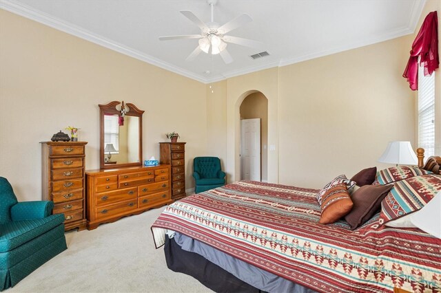 bedroom with arched walkways, carpet floors, ornamental molding, and ceiling fan