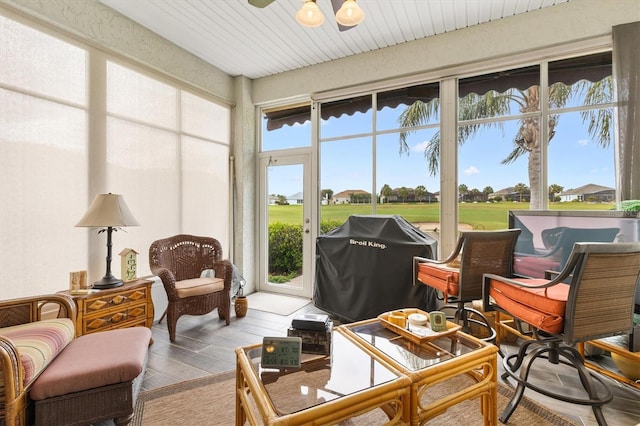 sunroom with wood finished floors and view of golf course