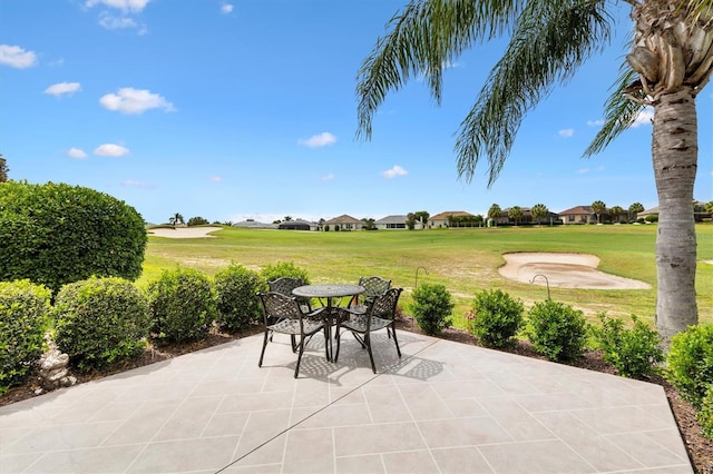 view of patio featuring golf course view, a residential view, and outdoor dining area