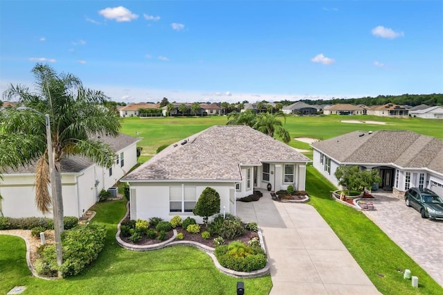 ranch-style house with concrete driveway, a residential view, stucco siding, and a front lawn