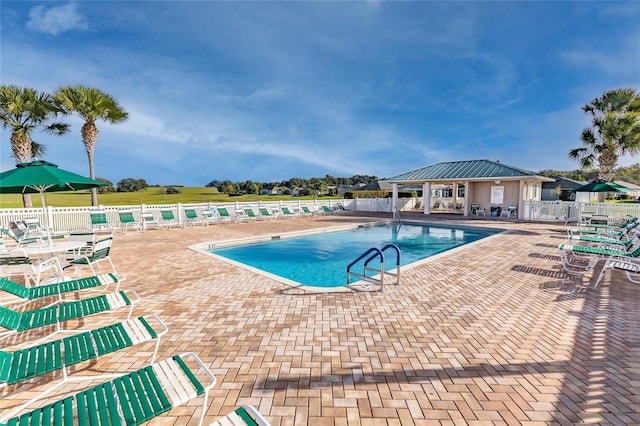 community pool featuring fence and a patio area
