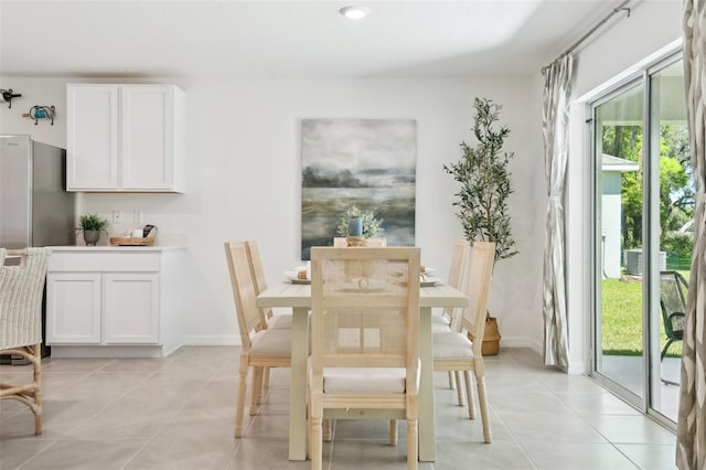 dining space with baseboards and light tile patterned flooring