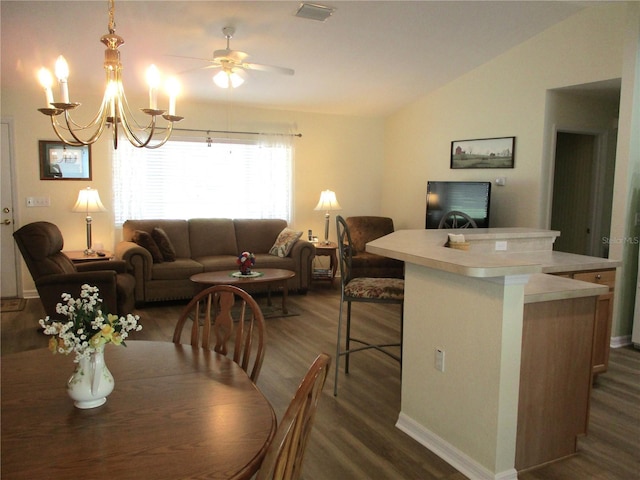 dining area featuring ceiling fan with notable chandelier, visible vents, baseboards, lofted ceiling, and dark wood-style floors