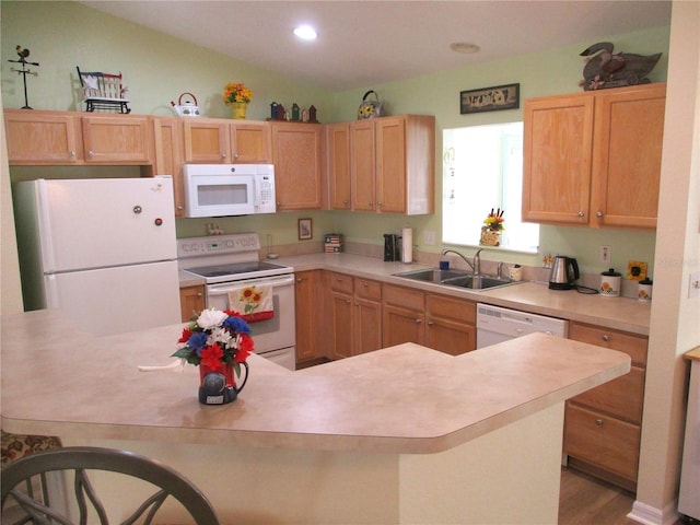 kitchen with a sink, white appliances, light countertops, and recessed lighting