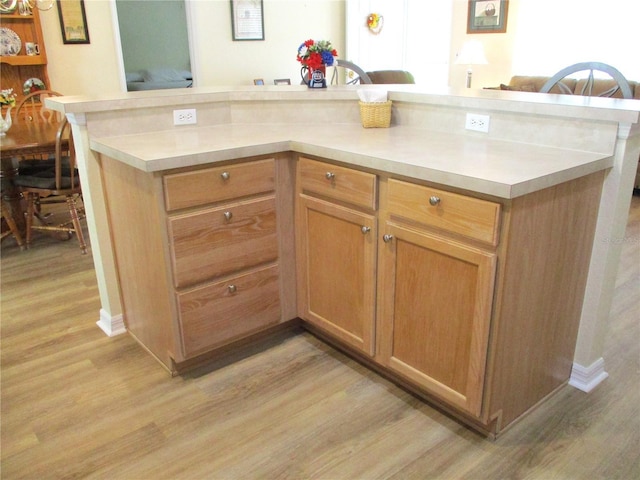 kitchen featuring light countertops, light wood finished floors, open floor plan, and a center island