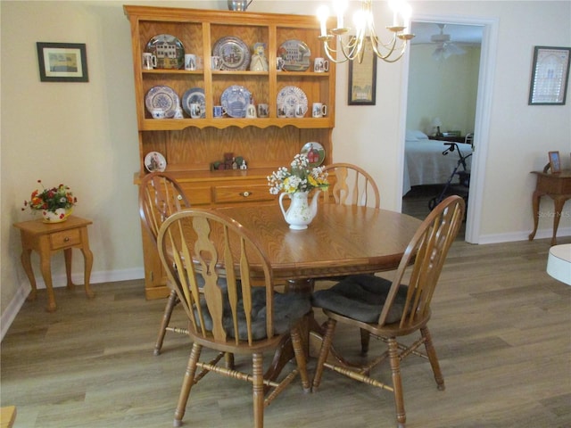 dining room with an inviting chandelier, light wood-type flooring, and baseboards