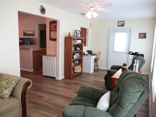 living area featuring baseboards, a ceiling fan, visible vents, and dark wood finished floors