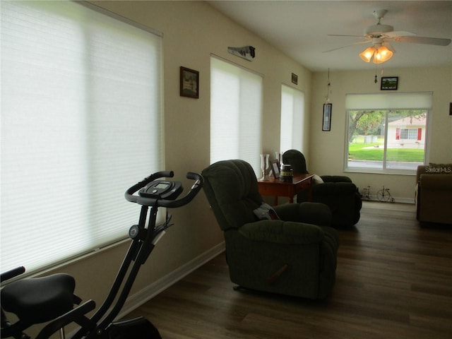living room featuring baseboards, ceiling fan, and wood finished floors
